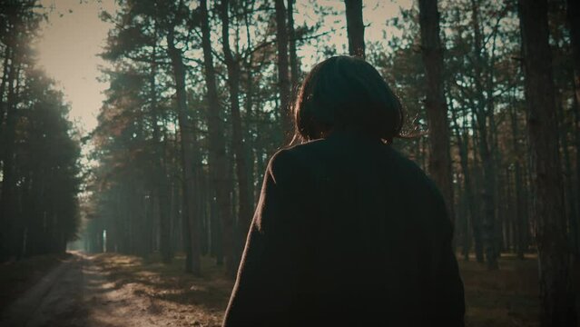 Serial killer disguised with wig brandishes axe ready to strike walking in forest. Maniac Murder and crime, Halloween horror day concept