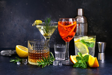 Set of alcoholic drinks (vodka, whiskey, aperol spritz, martini, lemon mojito ) on the bar counter.