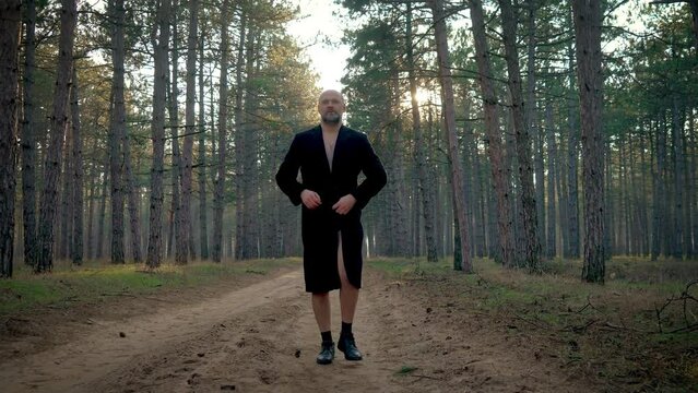 Male pervert in park, man exhibitionist opens coat in forest showing his underwear. Psychological disorders, sexual upbringing issues, emotional disturbances, depression