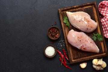 Raw chicken fillet or breasts with ingredients for cooking. Top view with copy space.