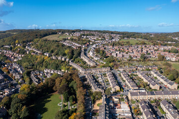 Aerial photo of the tow of Huddersfield in the Metropolitan Borough of Kirklees, West Yorkshire, England showing rows of terrace houses an homes in the Autumn time on a sunny day.