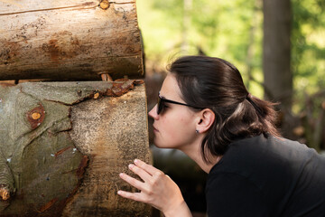 A young girl in sunglasses engaging with the natural environment by exploring the scent of freshly...
