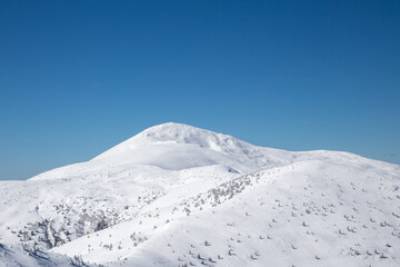 minimalistic winter mountain landscape, snowy mountain range on blue sky background