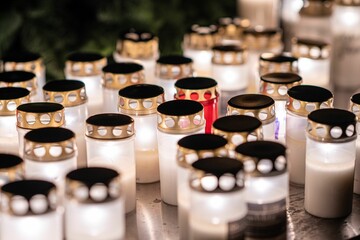 Closeup shot of many burning candles at a memorial in a cemetery
