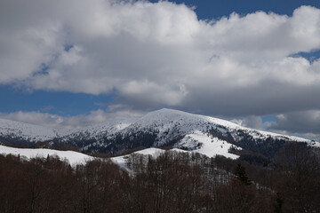 winter landscape, mountain range covered with snow, low clouds