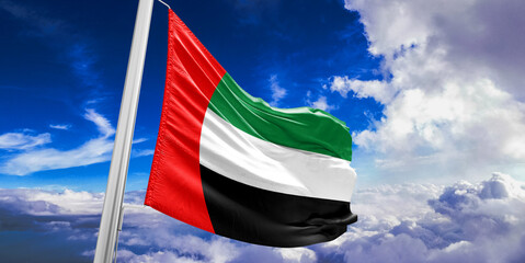 United Arab Emirates national flag cloth fabric waving on beautiful Blue Sky Background.