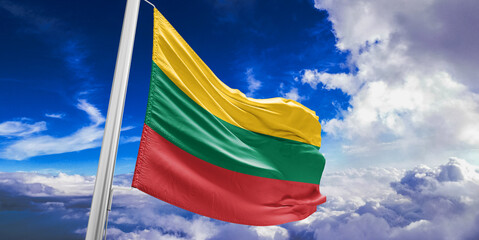 Lithuania national flag cloth fabric waving on beautiful Blue Sky Background.