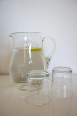Vertical shot of water carafe with glasses on table