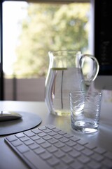 Vertical shot of water carafe with glass on table