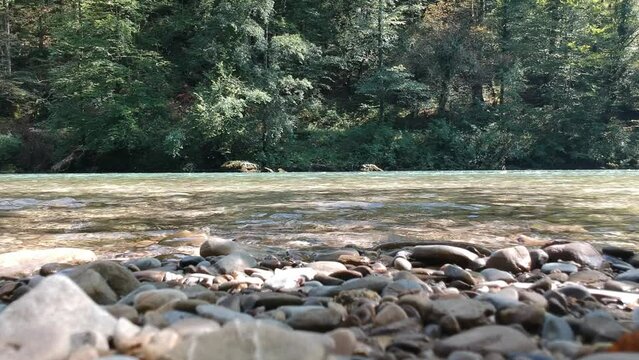 Beautiful view of a flowing river with trees in the background in Slovenia