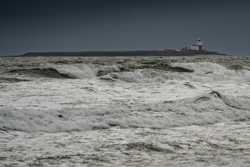 Aerial view of the rough sea waves and stormy sky at Coquet Island, northeast England - obrazy, fototapety, plakaty