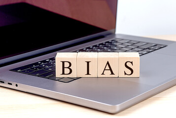 BIAS word on wooden block on laptop , business concept