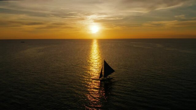 Colorful sunset above the sea surface with sail boats, aerial view Boracay, Philippines. Reflected sun on a water surface. Sunset over ocean. Seascape, Summer and travel vacation concept