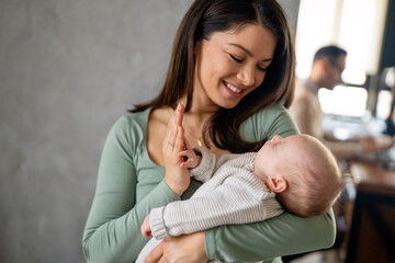 Loving mother carying of her newborn baby at home. Family parenting baby love concept. - 781957801