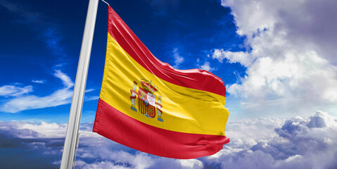 Spain national flag cloth fabric waving on beautiful Blue Sky Background.