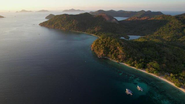 Traditional philippine boat bangka at sunset time in Linapacan, Philippines. Orange sky sunset paradise beach.