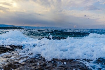 Scenic shot of the sea waves hitting the shore at sunset