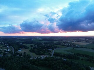Sun setting over a rural area with trees and fields