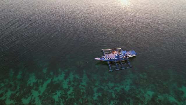 Traditional philippine boat bangka at sunset time in Linapacan, Philippines. Orange sky sunset paradise beach.