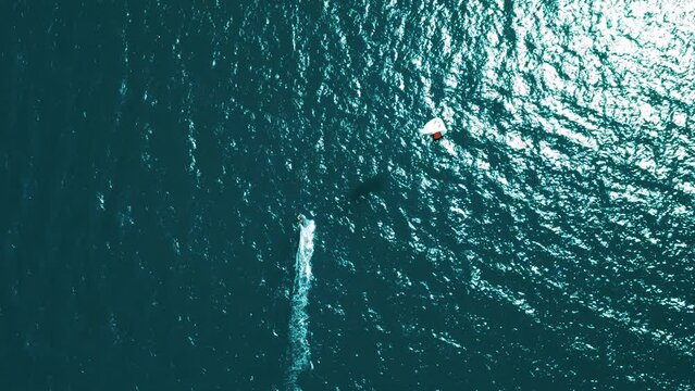 Aerial view kiteboarding. Colored parachutes of kites surf on blue water