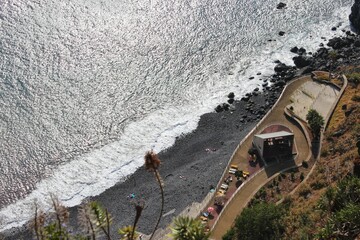 Bird's eye view of a dark sea with low tides at the beach by a skate park