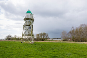 Small lighthouse on Hharriersand island in Weser river near Bremen - obrazy, fototapety, plakaty