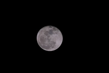Closeup of a full moon illuminating the dark night sky