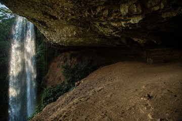 a cave with water falling into it and another cave above