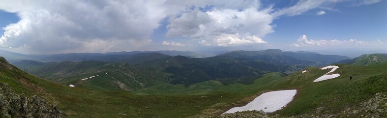 Naklejka premium Panoramic view of the rocky mountain range with the green field in Teghenis, Armenia