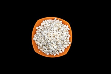 Jowar Popcorn In Orange Bowl, Isolated On Black Background