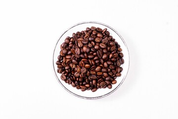 A Saucer Full Of Coffee Beans Isolated On White Surface