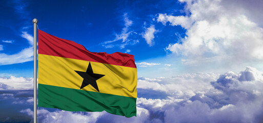 Ghana national flag cloth fabric waving on beautiful Blue Sky Background.