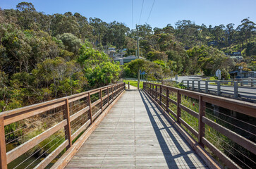 A wooden footbridge in Wye River offers pedestrian-only access and a tranquil passage over the lush gully on the scenic Great Ocean Road with a beautiful Australian nature landscape.