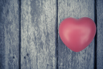 Red heart on wooden table