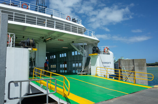 a Searoad ferry docked at a pier, with its deck or door lowered to allow cars to enter or exit the vessel. The Car and Passenger Ferry crossing between Queenscliff and Sorrento, VIC Australia.