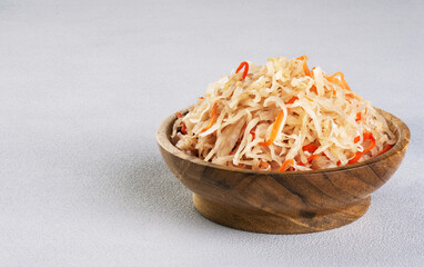 Sauerkraut with carrots in wooden bowl.