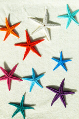 Colored starfish on white fine sand. - 782006623