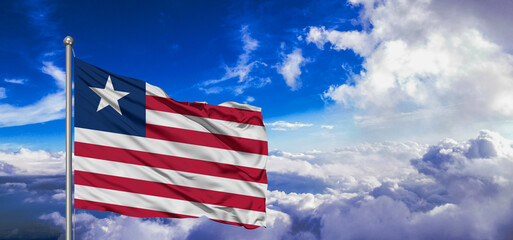 Liberia national flag cloth fabric waving on beautiful Blue Sky Background.