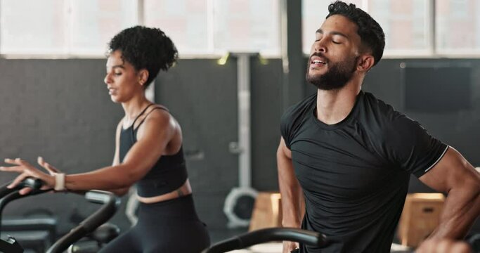 People, tired and cycle in gym, sweat and stop with training or exercise to build muscle on arms or legs. Friends, crosstrainer or bike for cardiovascular strength and slow down for break or energy.