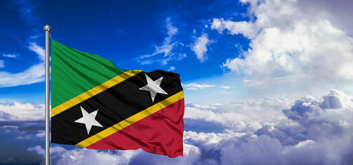 Saint Kitts and Nevis national flag cloth fabric waving on beautiful Blue Sky Background.