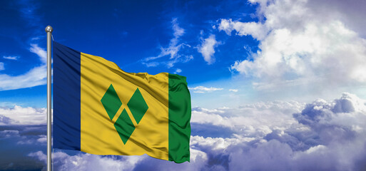 Saint Vincent and the Grenadines national flag cloth fabric waving on beautiful Blue Sky Background. - obrazy, fototapety, plakaty