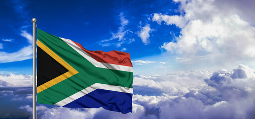 South Africa national flag cloth fabric waving on beautiful Blue Sky Background.