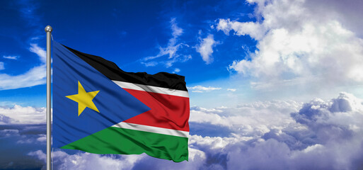 Sudan, South national flag cloth fabric waving on beautiful Blue Sky Background.