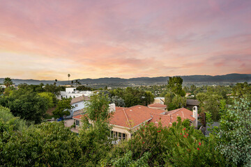 Obraz premium Sunset view behind a spacious house and trees in Encino, California