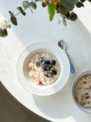 Vegan Rice porridge breakfast bowl with blueberries and raisins. Top view