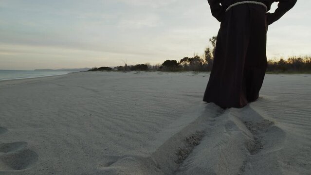 Monk Walks on the Beach in Prayer At Sunset