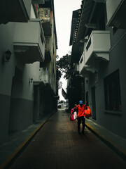 Panamanian Latino man with two bags walking through the old town of Panama City