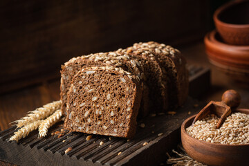 Rye bread with sunflower seeds on a wooden cutting board, closeup view - 782025621