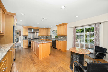 Kitchen with oak cabinets, oven, and breakfast table with chair in Encino, CA