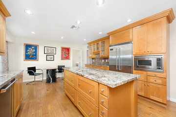 Spacious kitchen with wooden cabinets, stainless steel appliances in Encino, CA